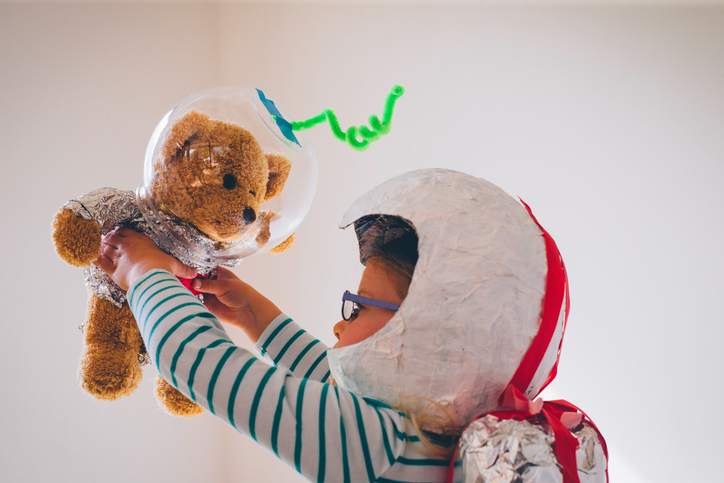 Kind spielt mit seinem Teddy Astronaut