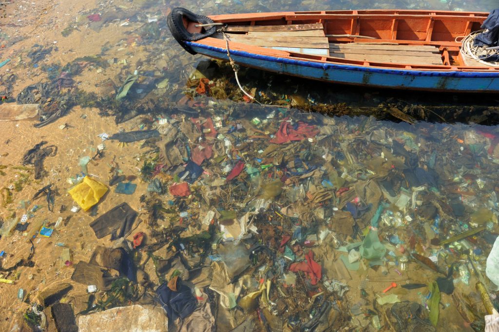 Boot über von Müll verschmutzten Wasser